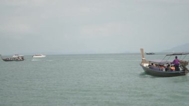 Thai travel boats with tourists cruising in the sea, Krabi, Thailand - 4K Horizontal video