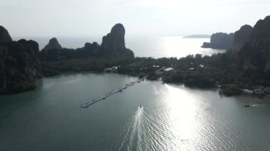  Fishers boat arriving at the pier of Railay Beach, Krabi, Thailand - Aerial view at sunset - 4K Horizontal video