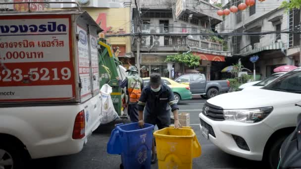 ごみ収集車が廃棄物トラックに廃棄物を投棄した後 交通によって空のゴミ箱を押し戻すタイのバンコク ワイド スローモーション 4K水平ビデオ — ストック動画