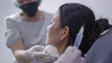 Yüz gençleştirme için kolajen estetik tedavisi sırasında elinde iğne tutan tanınmayan doktor - 4K Yatay Video