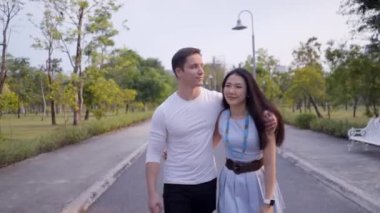 Asyalı ve Güney Afrikalı çiftler Bangkok parkında romantik bir randevuya çıkıyorlar - 4K Yatay Klip