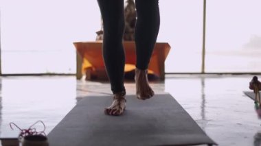 Yoganın ayaklarının ve bacaklarının Yoga minderi üzerinde yürüyüşünü izledik. Genç kız ön planda oynuyor. Çocuklu Yoga sınıfı. orta ekran - 4K Yatay Görüntü