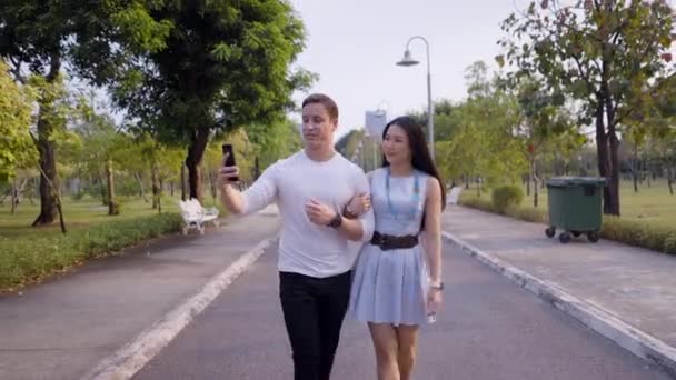 Matrimonio Interracial Toma Foto Con Smartphone Caminando Parque Bangkok Horizontal — Vídeo de stock