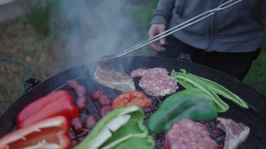 Erkeğin eti çevirmek için kıskaç kullandığına yakın çekim - yavaş çekim - 4K yatay video