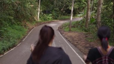 Chiang Mai, Tayland 'da Mae Kampong köyünde köpeklerle yürüyen iki kadın. Orta Çekim - 4K Yatay Görüntü