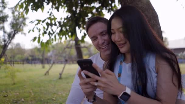 Pareja Feliz Usando Smartphone Sentado Banco Parque Primer Plano Clip — Vídeo de stock