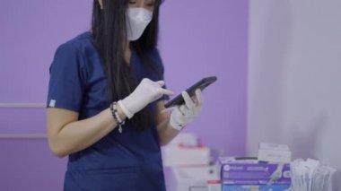 Kadın doktor işten bir çağrı aldı, telefonu omzuyla tuttu ve görevine devam etti - 4K Yatay Video