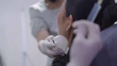 Kolajen enjeksiyonundan kaynaklanan şişkinlik ve ağrıyı önlemek için hastanın yüzüne buz konuyor - güzellik tedavisi - 4K yatay video