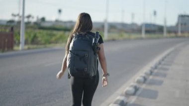 Memnuniyet yaratan kadın kırsalda bir yolun kenarında yürüyor - 4K Yatay Video