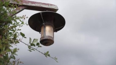 Yüzüklerin Efendisi 'nde asılı antik sokak lambası arka planda bulutlu gökyüzü - 4K Yatay video
