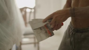 Adamın elleri spatuladan kurumuş boyayı çıkartıyor- ev reformasyonları- 4K yatay görüntü