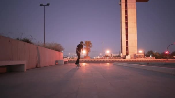 スケートの若い男が到着し カメラの前で停止 背景の青の時間 4K水平ビデオ — ストック動画