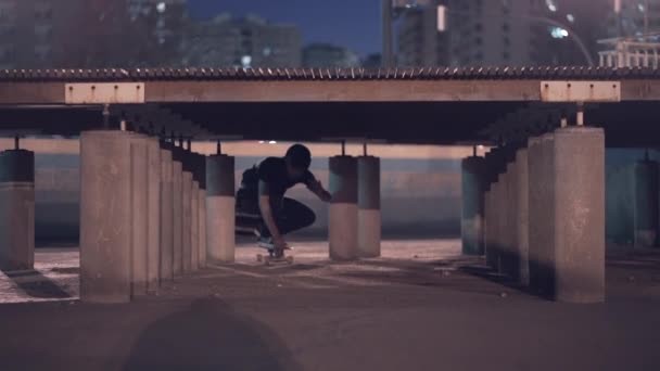 市内の市街地で木製の橋の下に滑り込むスケーターのフロントビュー 4K水平ビデオ — ストック動画