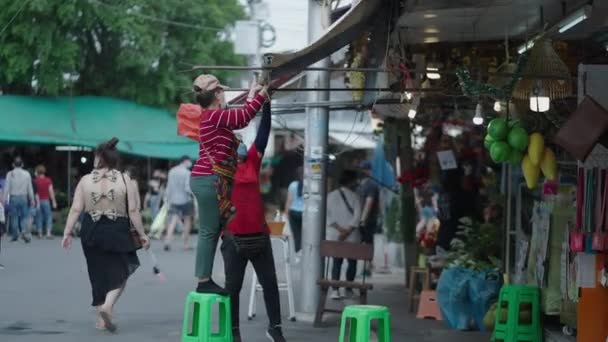 Perustaa Liiketoimintaa Chatuchak Market Bangkokissa Thaimaassa Kaksi Ihmistä Venyttää Kangas — kuvapankkivideo