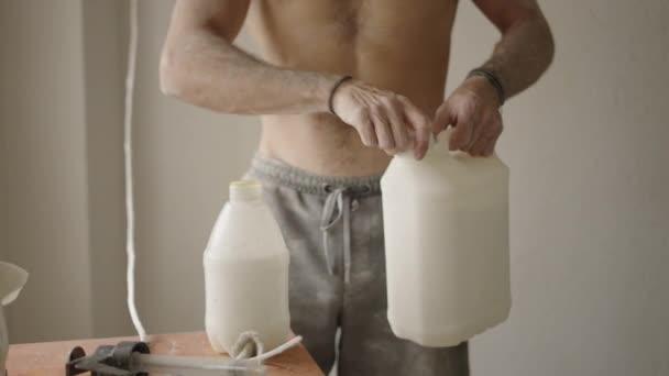 Faceless Man Opens Spray Bottle Pour White Paint Shirtless Dirty — Stock Video
