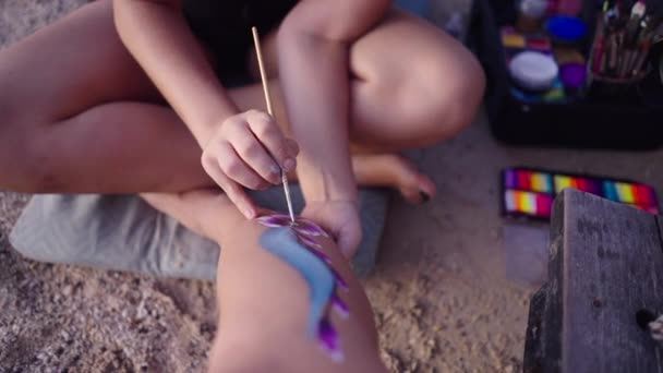 在泰国Koh Phangan的海滩上 无法辨认的Mua在女人的腿上涂满了身体的原始图案 4K水平视频 — 图库视频影像