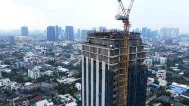İnşaat halindeki binanın insansız hava aracı görüntüleri. Çatıdaki inşaatçılar takdir ediyor. - 4K Yatay Görüntü