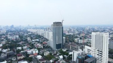 Ön planda kule vinçleri, arka planda sis. Şehir silüeti. İHA görüntüsü. - 4K Yatay Görüntü