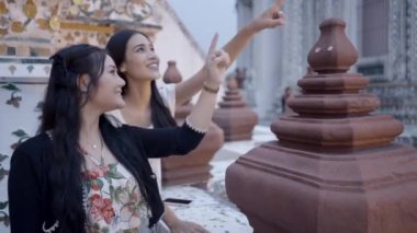 Kadın Asyalı arkadaşlar Bangkok 'taki Budist tapınağını ziyaret ediyorlar. Kadınlar manzaranın tadını çıkarıyor - 4K Yatay video