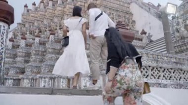Bir grup arkadaş Wat Arun tapınağına varır, üst kata yürürler. Geniş açı - 4K Yatay Görüntü