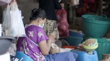 Hijyenik olmayan bir hindistan cevizi çiftliğinde çalışan iki yaşlı Asyalı kadın.