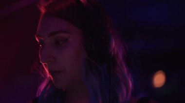 Gece kulübünde DJ olarak çalışan bir kadının ön görüntüsü. - 4K Yatay Görüntü