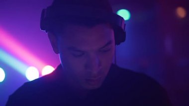 DJ başını sallıyor, kameraya bakıyor ve gülümsüyor - 4K Yatay Video