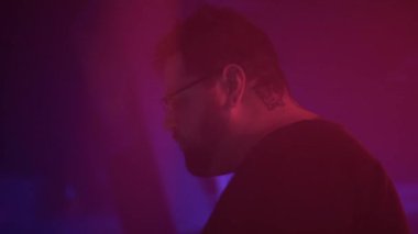DJ şarkı söyleyip dans ediyor. Gece kulübündeki müziği hisseden adam. - 4K Yatay Görüntü