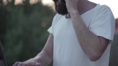 Adam dışarıda çalışıyor ve telefondan iyi haberler alıyor - 4K Yatay Video