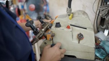 Kadın çilingir Tayland, Bangkok caddesinde anahtar kopyası yapıyor. Yakın plan - 4K Yatay Görüntü