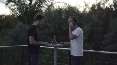 İki adam dışarıda çalışıyor, onu telefonla arıyor ve bir müşteriye teklifte bulunuyor ve reddediyor. - 4K Yatay Görüntü