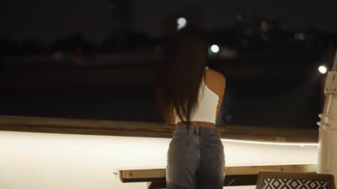 Neşeli Tayland modeli saçla oynarken arkasını döner ve gülümser - 4K Yatay Video