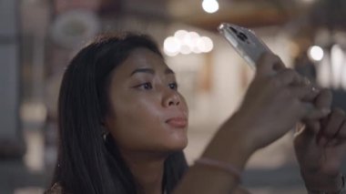 Bangkok 'ta fotoğraf çekmek için akıllı telefon kullanan sevimli Taylandlı kadını kapat - 4K Yatay video