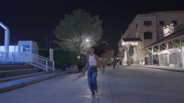 Coşkulu Asyalı kız lunaparkta koşarken ve dönerken eğleniyor - şirin çocuk tavrı - 4K yatay video