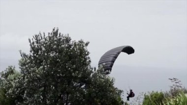 Maunganui Dağı 'nda yamaç paraşütü yapan ve yere inen adam - 4K Yatay Video