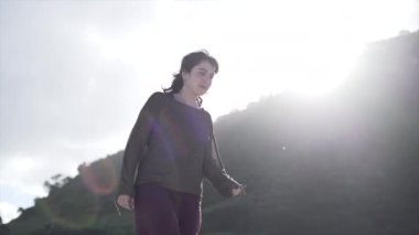 Güneşli bir günde Maunganui Dağı sahilinde yürüyen kadın - 4K Yatay Video