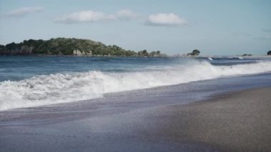 Maunganui Dağı 'nda gün batımında kıyıda mavi dalgalar kırılıyor - 4K Yatay video