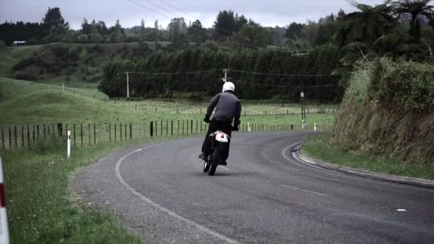男子骑摩托车绕一个弯道在绿色的草地上在新的热情 4K水平视频 — 图库视频影像