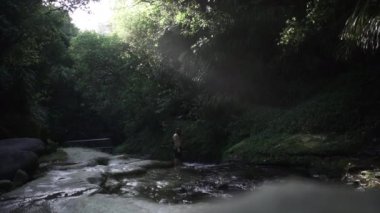 Adam Yeni Zelanda 'da bir şelalenin yanında yürüyor - 4K Yatay video