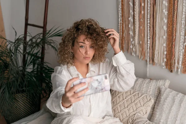 Joven Mujer Tranquila Tocando Pelo Rizado Tomando Autorretrato Teléfono Celular —  Fotos de Stock