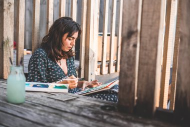 Genç ressam kız elinde fırçayla yerde oturuyor - yaşam tarzı konsepti