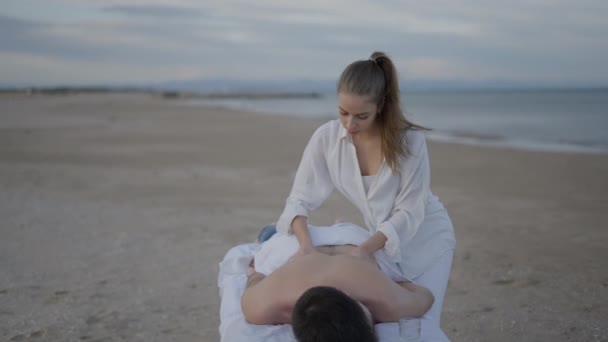 Empreendedor Massagista Massagem Suave Para Jovem Cliente Masculino Praia Horizontal — Vídeo de Stock