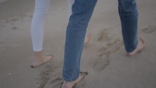 カップルがビーチの砂で足跡を残して調整歩く 4K水平ビデオ — ストック動画