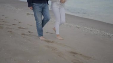 Çıplak ayaklı iki arkadaş kıyı boyunca yürür. Tanımlanamayan arkadaşlar yürüyüşe çıkıyor - 4K Yatay Video
