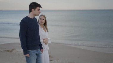 Arkadaşlar sahilde yürürken sohbet ediyorlar. Kışın sabah yürüyüşü - yavaş çekim - 4K Yatay video