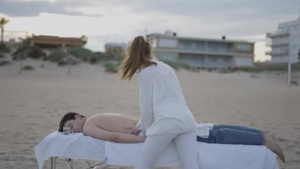 Młody Hiszpański Mężczyzna Korzysta Relaksującego Masażu Plaży Dom Tle Poziome — Wideo stockowe