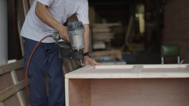 木製のクレート収納ボックスに空気圧ネイルガンを使用して男 クローズアップ 4K水平ビデオ — ストック動画