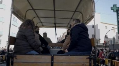 Valencia, İspanya 'da San Antonio Abad Festivali sırasında eski bir at arabasına binen insanlar. Geri çekme - 4K Yatay Video