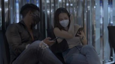 Çok ırklı çiftler iyi vakit geçirsin. Kız oğlanın resmini gösteriyor ve birlikte gülüyorlar - 4K Yatay Video