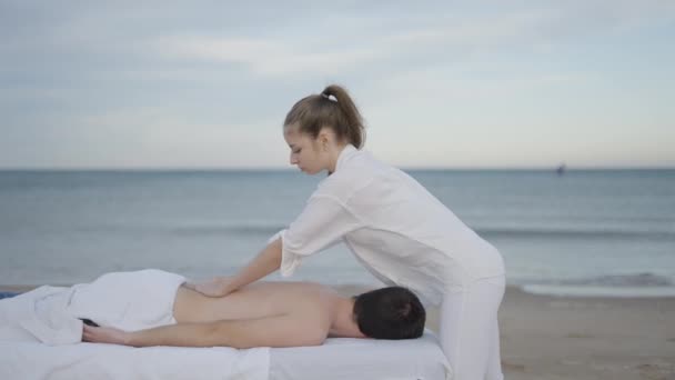 Boční Pohled Profesionálního Kosmetika Provádějícího Masáž Pláži Mladém Muži Horizontální — Stock video